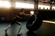 © Yakov Knyazev/Stocksy - Caucasian strong athlete woman working out with heavy tire indoors