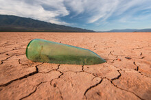 Aged Glass Bottle Stuck In The Mud As A Symbol Of Drought