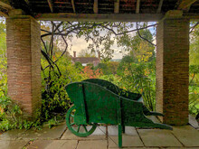 Artistic Photo Of An Autumn Garden With Wood Wheelbarrow In Front And Place For Writing
