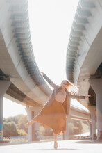 Young Blonde Woman Dancing Under A Bridge
