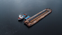 Top-view Of A Small Ship Near The Empty Barge