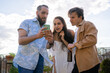 © Luis Velasco/Stocksy - Three Friends Checking A Cellphone Outdoors.