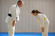 Young female judo girl showing respect to old judo teacher