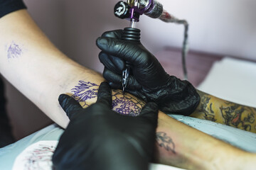 Canvas Print - Tattoo artist tattooing a dragon on a man's arm