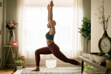 Young Woman Practices Yoga At Home