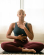 © Melissa Alexander/Creative Flame - Black woman breathing and doing meditation at home