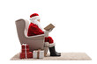 © Ljupco Smokovski - Full length profile shot of santa claus sitting in armchair and reading a book