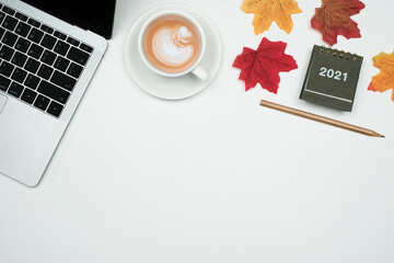 Wall Mural - Flat lay, Top view 2021 plan and business office concept on white table desk background with laptop computer and coffee cup, calendar 2021 and maple leaves, goal plan action concept with copy space