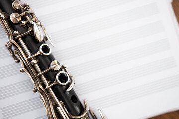 Closeup of clarinet keys against blurry staff paper background