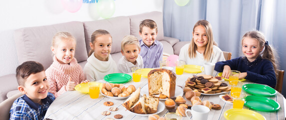 Wall Mural - Group of happy children enjoying friend birthday during dinner