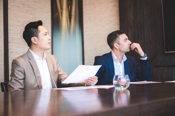 Wall Mural - From above of group of diverse colleagues in formal clothing discussing business ideas while gathering at table in modern office and working together