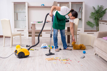 Young male contractor cleaning the flat after kids' party