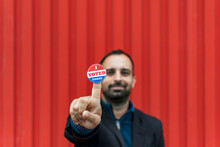 Man Holding A Sticker With The American Flag Colors With 'I Voted Today' Written On It