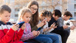© JackF - Group of boys and girls addicted in their phones spending time together outdoors