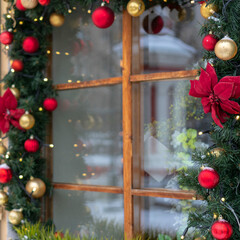 Closeup shot of windows decorated with branches of fir and Christmas tinsel