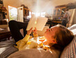 © Mint Images - teenage girl reading book at home in early morning light