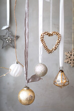 Christmas Decorations, Close Up Of Silver, White And Golden Christmas Baubles On Ribbons