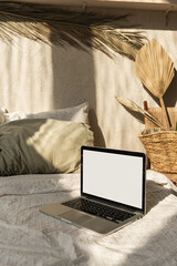 Wall Mural - blank screen laptop in bed with pillows and linens. boho style home interior design with sunlight sh