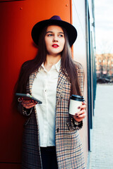 young pretty girl outside in city street with coffee happy smiling wearing hat, lifestyle fashion peopple concept