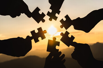 Wall Mural - Silhouette  hands connecting  jigsaw puzzle piece against sunrise, Business solutions,  teamwork, partnership, success, goals and strategy concepts.