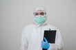 © Chanakon - A portrait of virologist put on PPE suit holding clipboard beside arm isolated on white background. Personal Protective Equipment Concept..