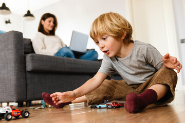 Boy playing on the floor with car toys