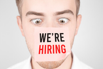 Poster - man with a red sticker on his nose reads the text we are hiring