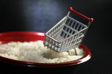 Miniature shopping cart model put in the rice bowl scene represent argricultural product and e commerce concept related idea.