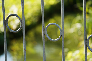 Wall Mural - Closeup shot of a metal fence with circles in the middle of the lines