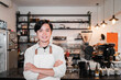 © Odua Images - barista standing with crossed hands in front a coffee shop at her work