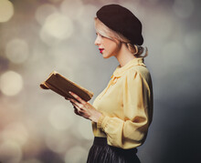 Beautiful Girl In Vintage Clothes With Book On Gray Background