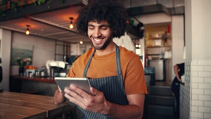 Canvas Print - Shot of a successful smiling young man wearing apron using a digital tablet in his coffee shop