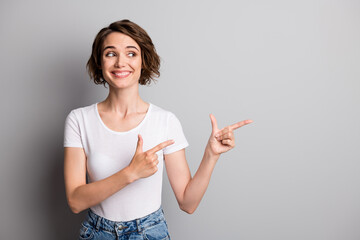 Poster - Photo of young beautiful woman look point fingers empty space ad promo choice recommend isolated over grey color background