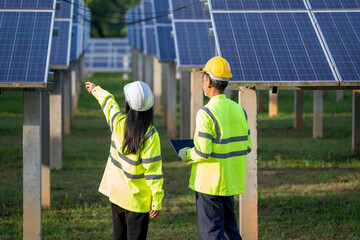 Poster - Technicians and engineer in long sleeve shirts reflective vests and hard hats discussing something about solar panel power,Solar power plant to innovation of green energy for life.