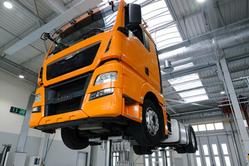 Truck on a lift in a car service. Service maintenance of trucks. The car is serviced in a large garage, diagnostics, repair, station.