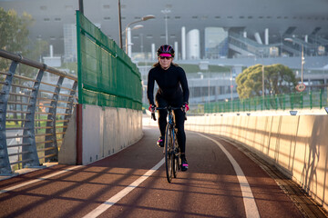 Morning exercise of a woman on a bike in the city. Outdoor sports. Krestovsky Island Saint Petersburg Russia.