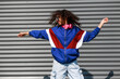 Cool black girl with curly hair, glasses, 90s, 80s, retro hip hop style, dancing against a metal wall, dynamics and expression