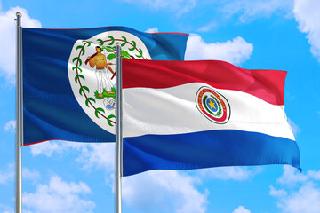 Paraguay and Belize national flag waving in the windy deep blue sky. Diplomacy and international relations concept.