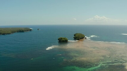 Wall Mural - Tropical islands in the ocean with waves crashing on the shore, top view. Siargao, Philippines. Summer and travel vacation concept.