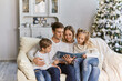 © Inna Vlasova - friendly family reading book on Christmas evening