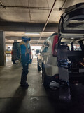 Fototapeta  - woman near white suv at parking place in snowboard equipment