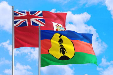 New Caledonia and Bermuda national flag waving in the windy deep blue sky. Diplomacy and international relations concept.