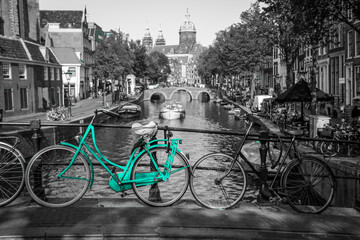 Wall Mural - An azure bike on the streets of Amsterdam. Symbol for clean and ecological urban transport. Isolated in a black and white background. 