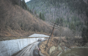 Wall Mural - Winter trip to the mountains. Dangerous road over the cliff