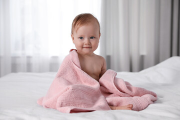 Canvas Print - Cute little baby with soft pink towel on bed after bath