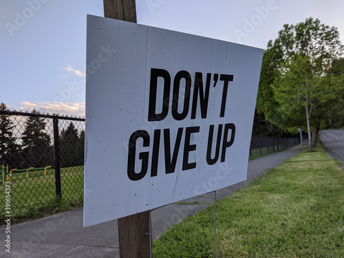 a Don\'t Give Up motivational sign in a yard during the COVID-19 pandemic