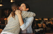 © Jacob Lund - Female friends greeting each other with a hug in a cafe