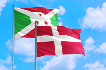Wall Mural - Denmark and Burundi national flag waving in the windy deep blue sky. Diplomacy and international relations concept.