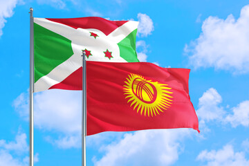 Wall Mural - Kyrgyzstan and Burundi national flag waving in the windy deep blue sky. Diplomacy and international relations concept.