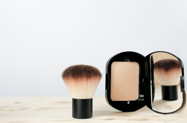 Wall Mural - compact foundation powder with brush. beauty product for women. brush reflection in the mirror.